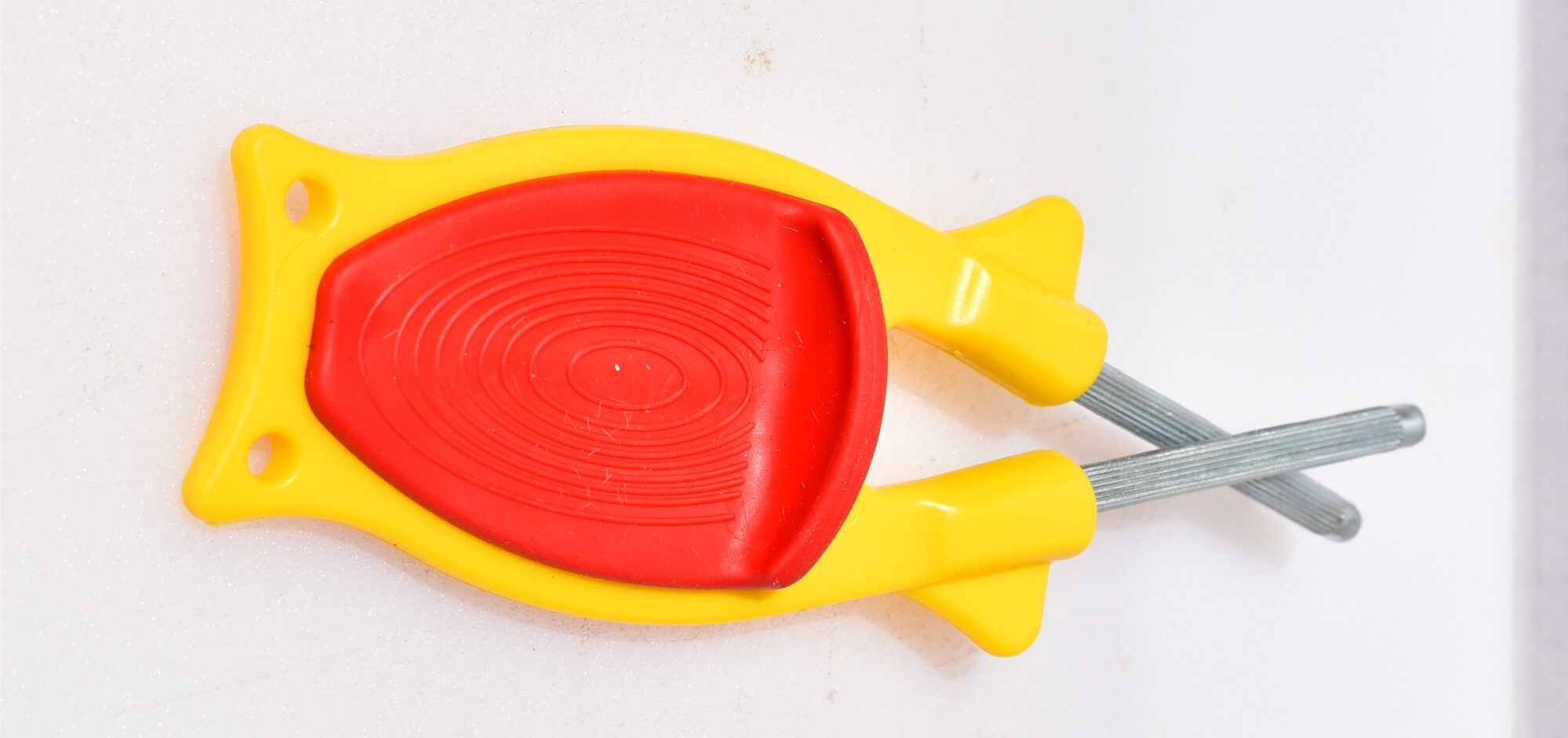 Red nonslip thumb grip on a yellow Block sharpener handle
